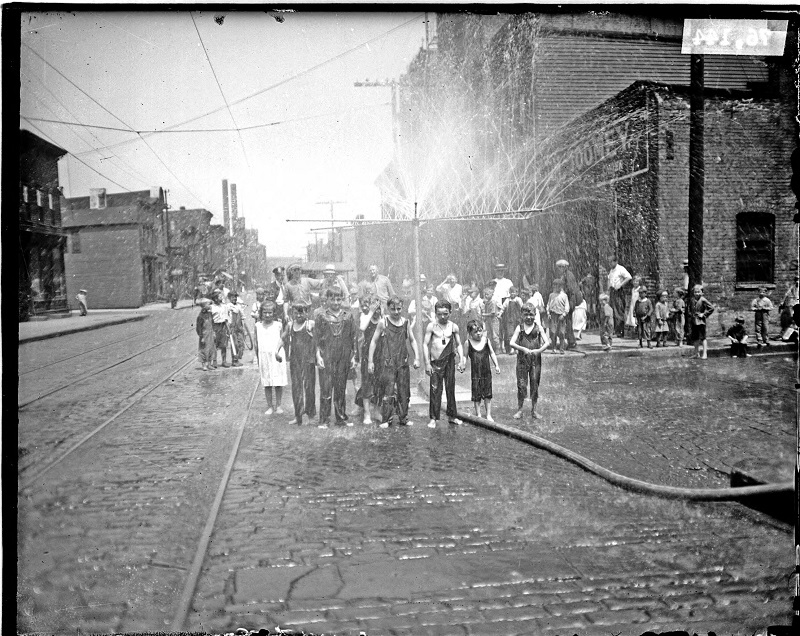 Large group of children standing under showers over the street. Image of a large group of children standing under showers over the street in Chicago, Illinois. Source: DN-0076144, Chicago Daily News negatives collection, Chicago Historical Society. Date: 1923