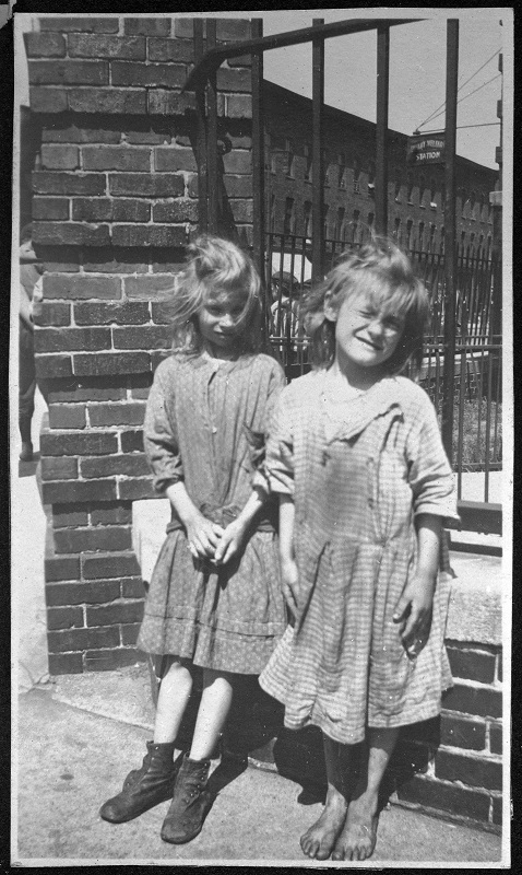 Two girls, one barefoot, in front of George Washington School. Description: Two girls, one barefoot, in front of George Washington School, Chicago, IL. Source: ICHi-26833. Chicago History Museum. Reproduction of photograph, photographer unknown. Date: ca. 1900-1939.